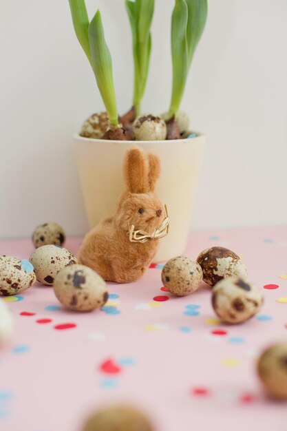 Ovos de codorna de coelhinho da páscoa e tulipas em um vaso de flores decorações de páscoa