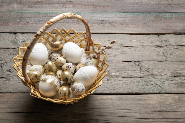 Ovos de codorna de Páscoa em uma cesta em um velho de madeira