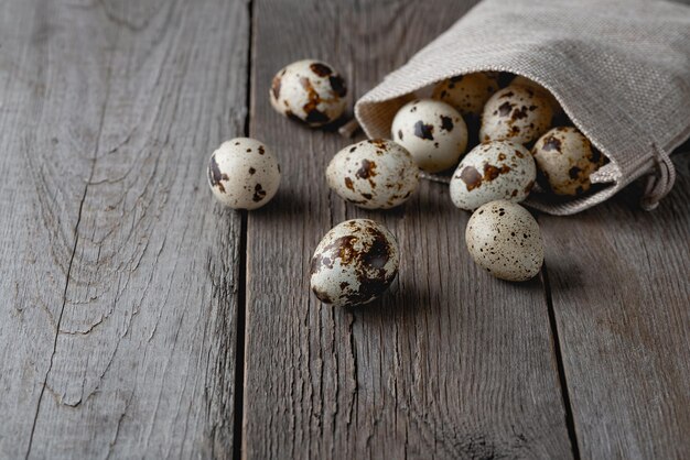 Ovos de codorna em um saco em uma velha mesa de madeira