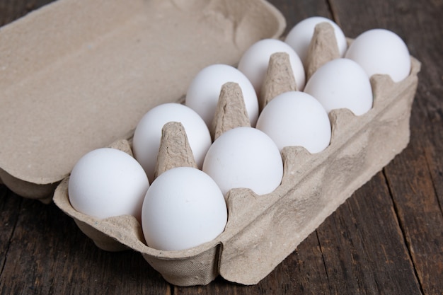 Ovos de galinha branca em uma caixa de papelão