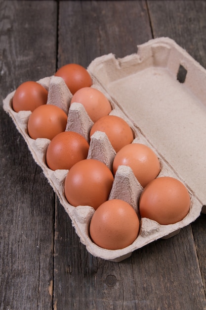 Ovos de galinha crua na mesa de madeira