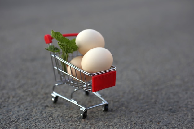 Ovos de galinha em um carrinho de supermercado mini na estrada.