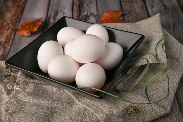 Ovos de galinha estão sobre uma mesa de madeira na cozinha