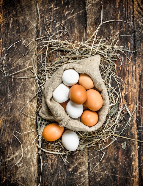 Ovos de galinha frescos em um saco velho. Sobre um fundo de madeira.