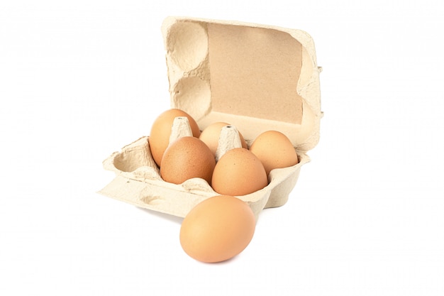 Ovos de galinha marrom em caixa isolado no branco