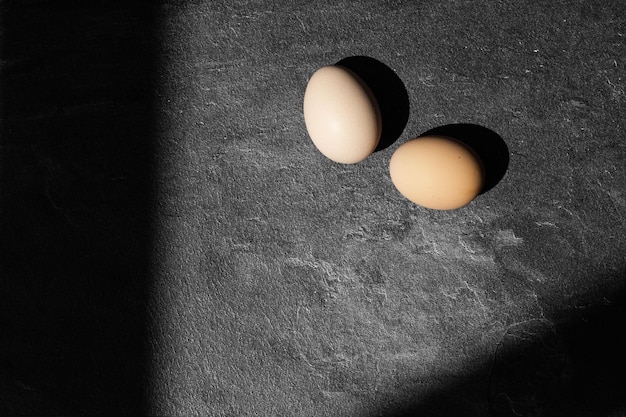 Ovos de galinha orgânica em fundo escuro de madeira com espaço de cópia