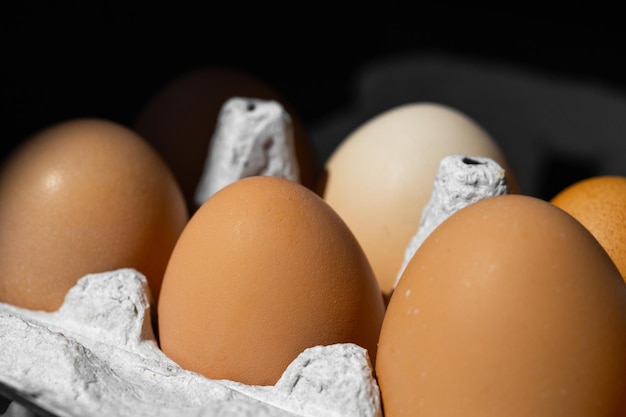 Ovos de galinha orgânica em fundo escuro de madeira com espaço de cópia