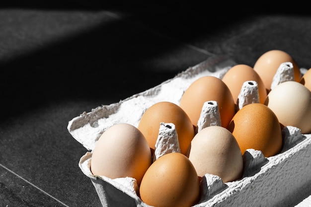 Ovos de galinha orgânica em fundo escuro de madeira com espaço de cópia