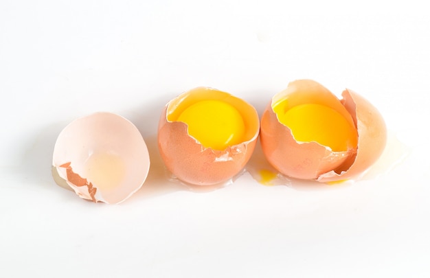 Ovos de galinha quebrados isolados na superfície branca