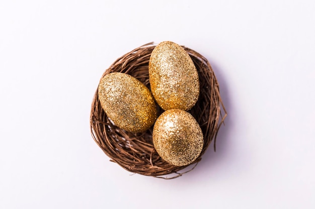 Ovos de glitter dourados em um ninho conceito de finanças de fundo de Páscoa