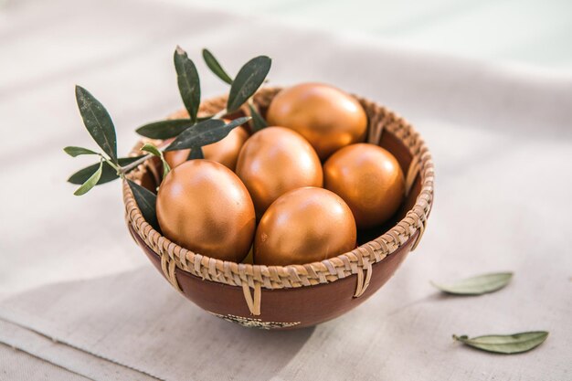 Ovos de ouro na tigela O conceito mínimo Um cartão de Páscoa com uma cópia do local para o texto