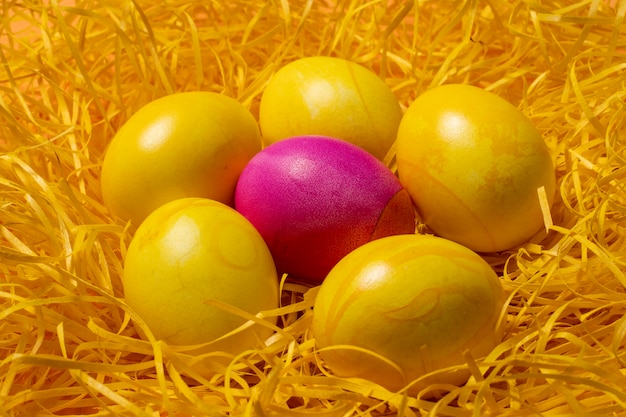 Ovos de Páscoa amarelos em fundo de palha
