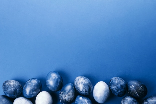 Ovos de Páscoa azul lindo grupo ombre com ovos de codorna e penas sobre um fundo azul