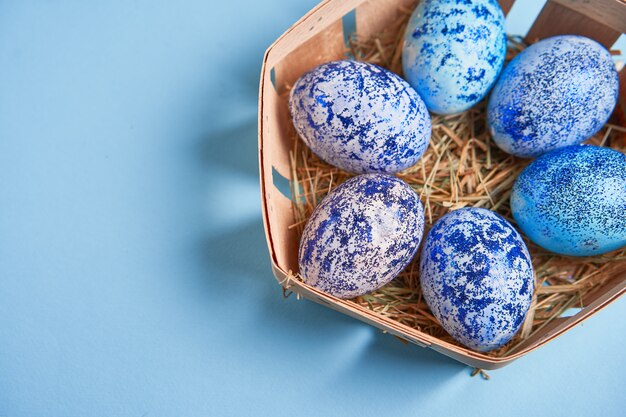 Ovos de Páscoa azul na cesta em fundo azul