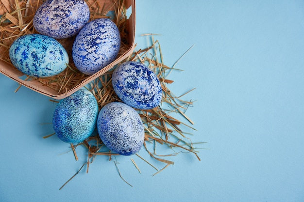 Ovos de Páscoa azul na cesta em fundo azul