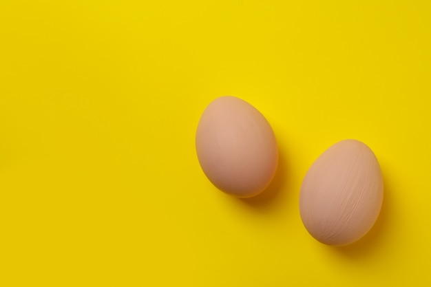 Ovos de Páscoa bege lindos em fundo amarelo