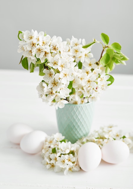 Ovos de Páscoa brancos e ramo de primavera com flores. Primavera Páscoa Flores Cereja florescendo. Flores da primavera. Bela Orchard.Springtime