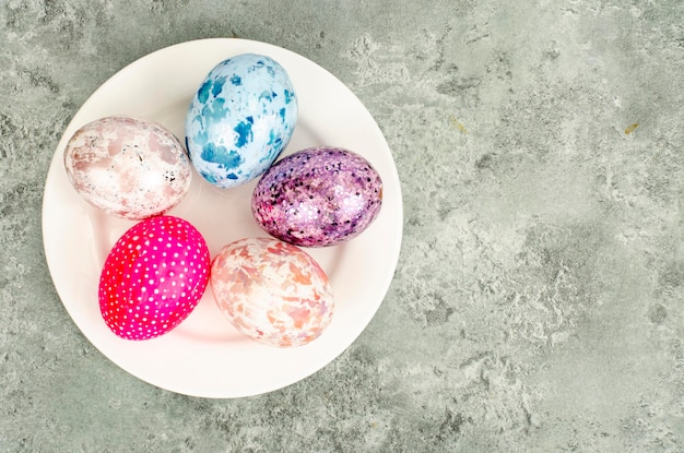 Ovos de Páscoa coloridos brilhantes no prato, fundo de férias. Foto de estúdio