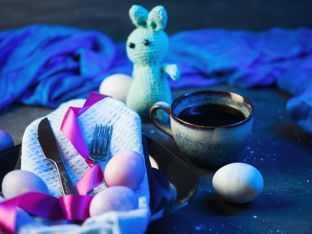 Ovos de páscoa coloridos de coelhinho de páscoa em uma placa preta xícara de café expresso luz neon colorida