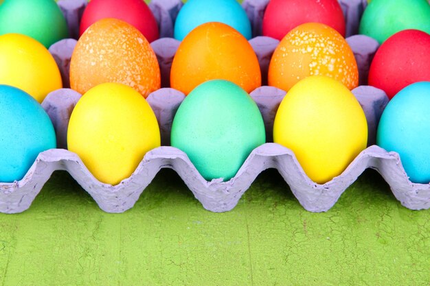 Foto ovos de páscoa coloridos em bandeja sobre fundo de madeira