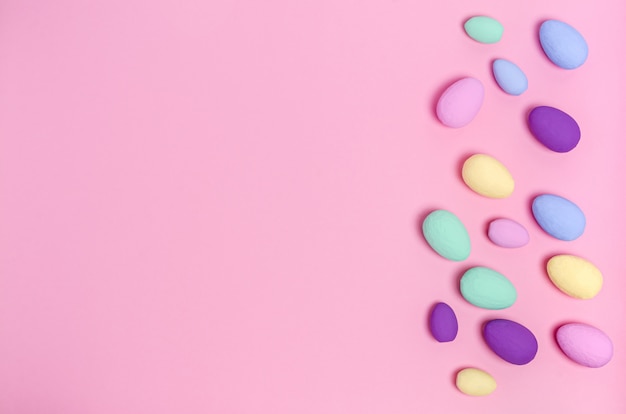 Foto ovos de páscoa coloridos em um fundo rosa, cópia espaço, plana leigos