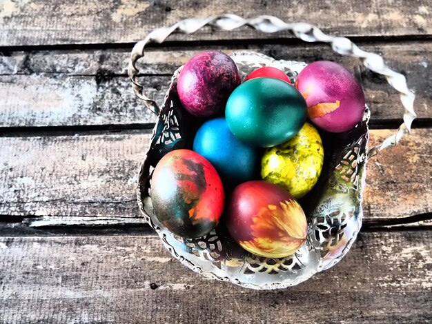 Ovos de páscoa coloridos em uma velha tigela de doces de metal em uma mesa de madeira Páscoa a Ressurreição de Cristo a Ressurreição Brilhante de Cristo o feriado mais antigo e cristão