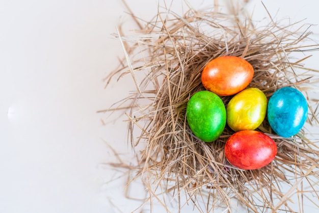 Ovos de Páscoa coloridos estão em um canudo, como em um ninho.