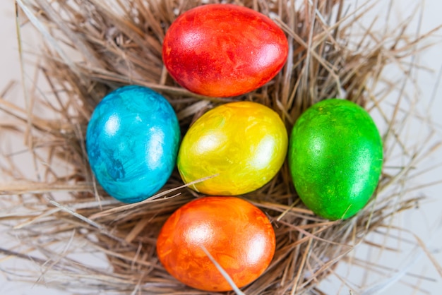 Ovos de Páscoa coloridos estão juntos em um canudo em forma de ninho. Feliz Páscoa