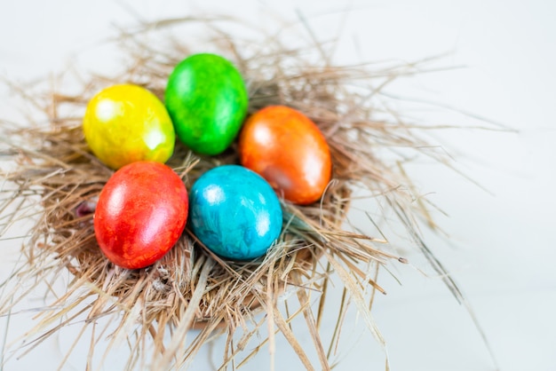 Ovos de Páscoa coloridos estão juntos em um canudo em forma de ninho. Feliz Páscoa