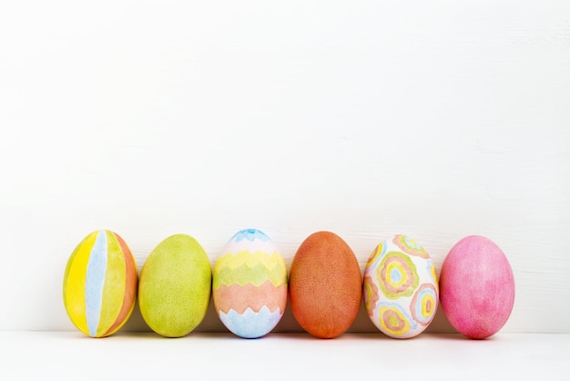 Ovos de Páscoa coloridos feitos à mão sobre fundo branco Ovos de Páscoa em linha sobre branco