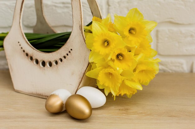 Ovos de páscoa coloridos na mesa coelhinho da páscoa flores amarelas em uma maquete de cesta