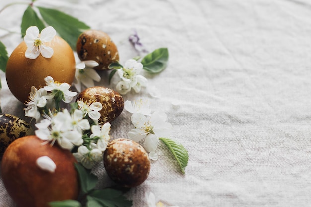 Ovos de Páscoa com flores de primavera em fundo de linho rústico com espaço para texto Estética de férias