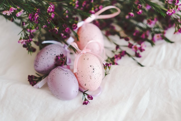 Ovos de Páscoa com flores em tecido de linho branco Primavera e conceito de Páscoa