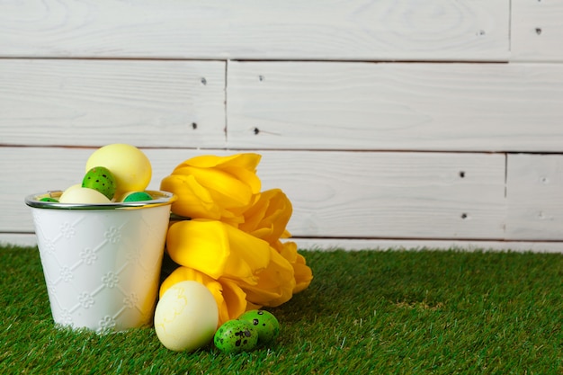 Ovos de Páscoa com flores na grama verde