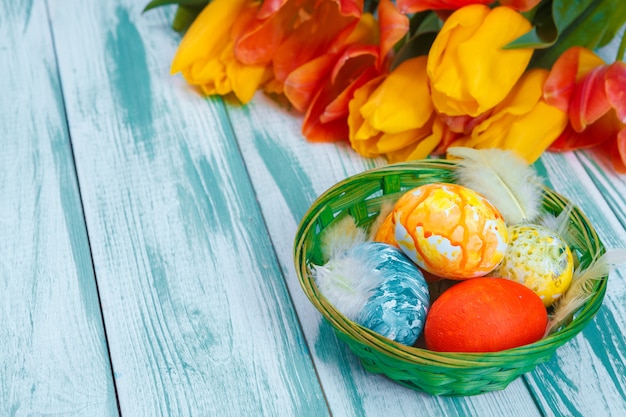 Ovos de páscoa com tulipas em madeira azul