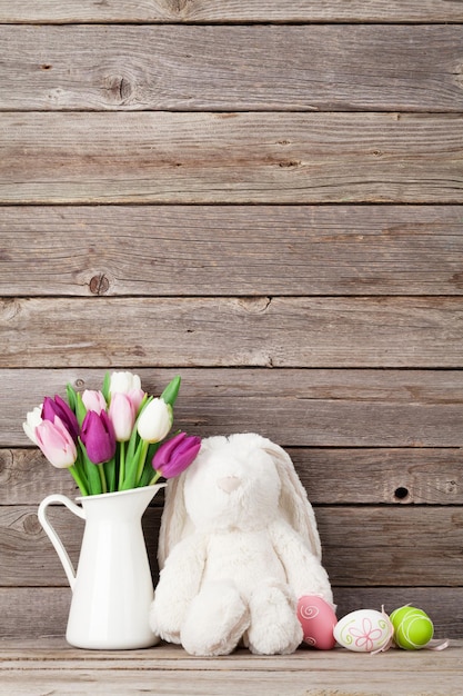 Ovos de Páscoa de brinquedo de coelho e tulipas coloridas