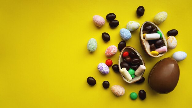 Ovos de Páscoa de chocolate deliciosos, doces em fundo amarelo brilhante