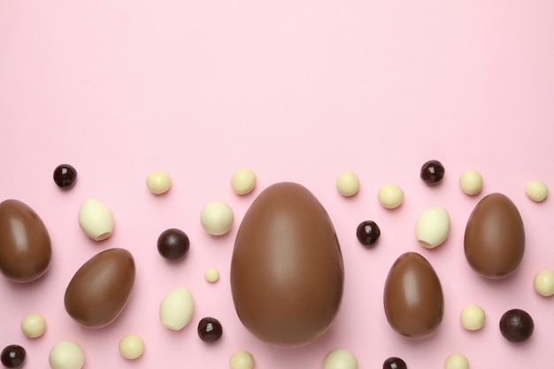 Ovos de Páscoa de chocolate e doces na superfície rosa