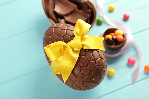 Foto ovos de páscoa de chocolate na mesa colorida de madeira