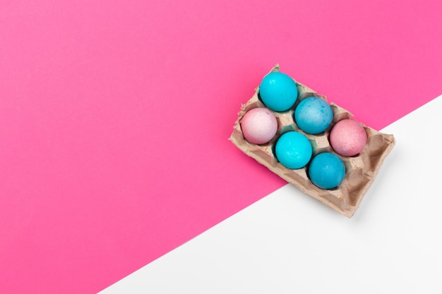 Ovos de Páscoa de cor de doces sobre fundo de papel rosa
