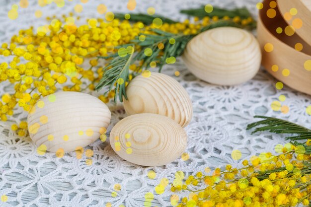 Ovos de páscoa de madeira com uma mimosa