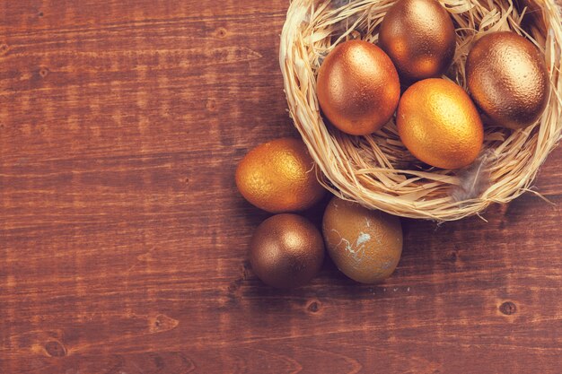 Ovos de Páscoa de ouro sobre fundo de madeira