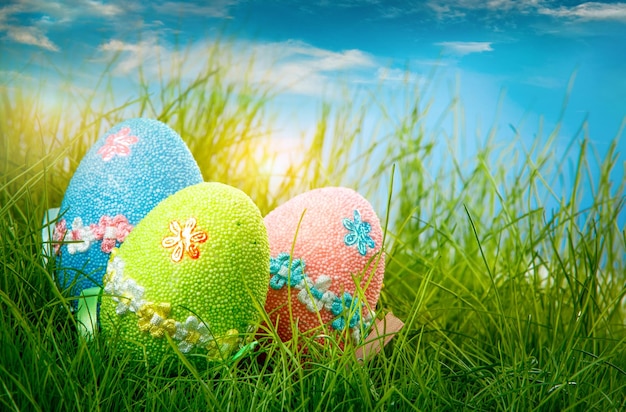 Ovos de páscoa decorados na grama no fundo do céu azul