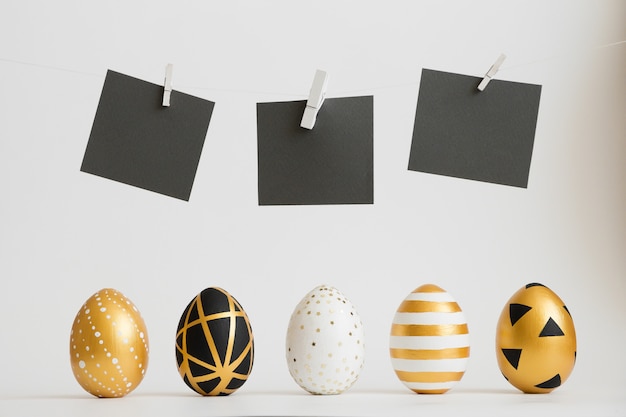 Ovos de Páscoa decorados ovos de ouro em uma linha com adesivos de texto em preto