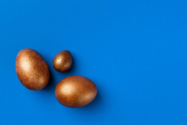 Ovos de Páscoa dourados modernos isolados em azul