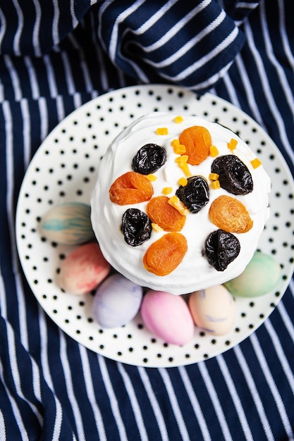 Ovos de páscoa e bolo de páscoa estão em um prato deitado em um avental azul listrado conceito de feriado religioso da páscoa