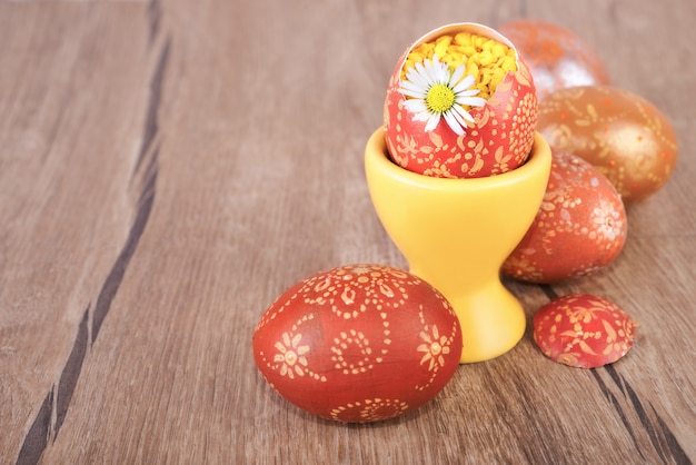 Ovos de páscoa e daisy flor na mesa de madeira