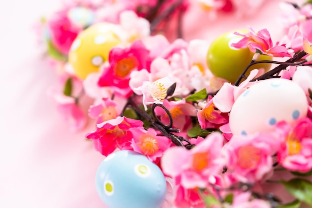 Ovos de páscoa e flores cor de rosa em um backgorund rosa.