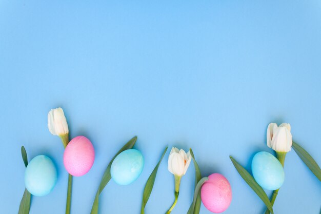 Ovos de páscoa e flores da primavera em azul