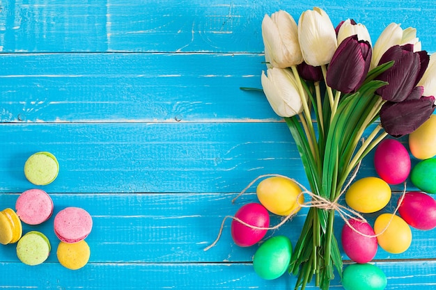 Ovos de páscoa e tulipas em pranchas de madeira azuis